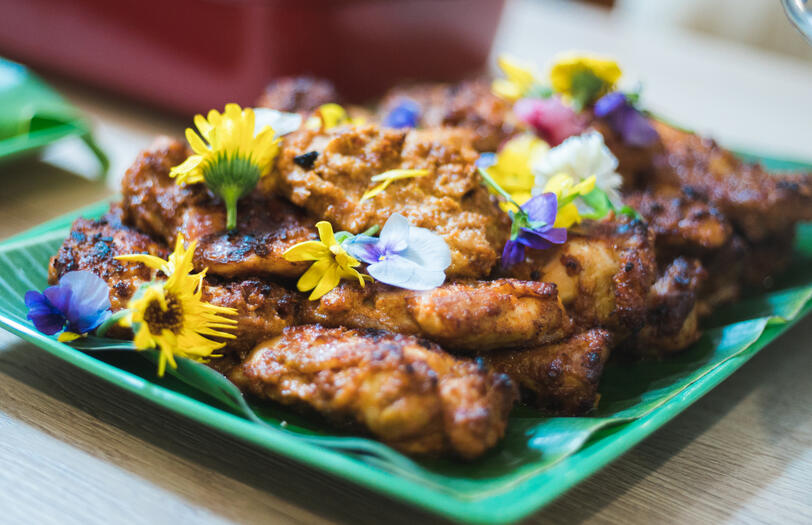 Grilled ayam percik served on banana leaf with spiced marinate.