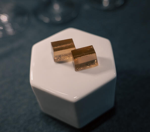 Two translucent Tieguanyin tea gummies presented on a small raised glass serving piece.